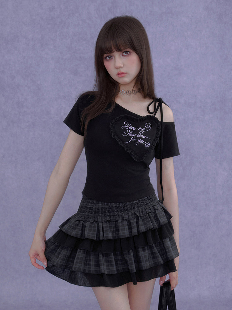 Model wearing a black asymmetric Cyber Y2K heart graphic crop top with ruffle embroidery and shoulder ties.