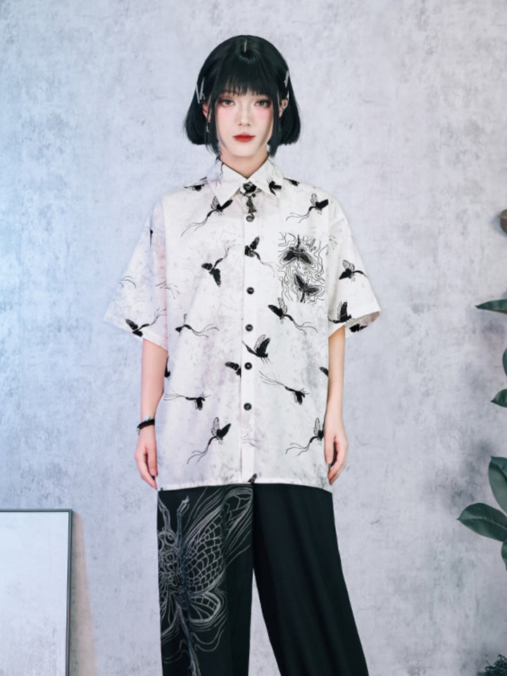 Unisex oversized short-sleeve button-up shirt in smoky marble white with all-over black moth and butterfly hand-drawn graphics.