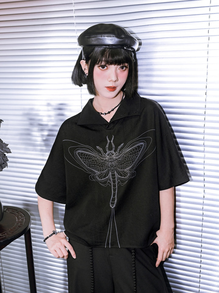 Black avant-garde streetwear top with a high buttoned turtleneck and a large grey linear moth graphic on the front.