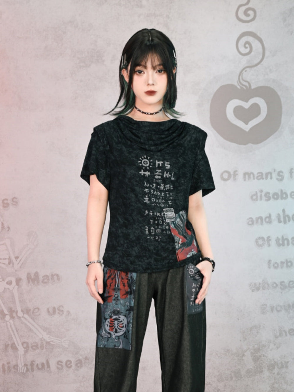 Front view of a model wearing a cyber-grunge acid wash graphic tee in faded charcoal black. The shirt features a unique draped cowl neckline and cryptic white symbols paired with a red-toned patch graphic near the hem. She is styled with dark patchwork pants and a choker