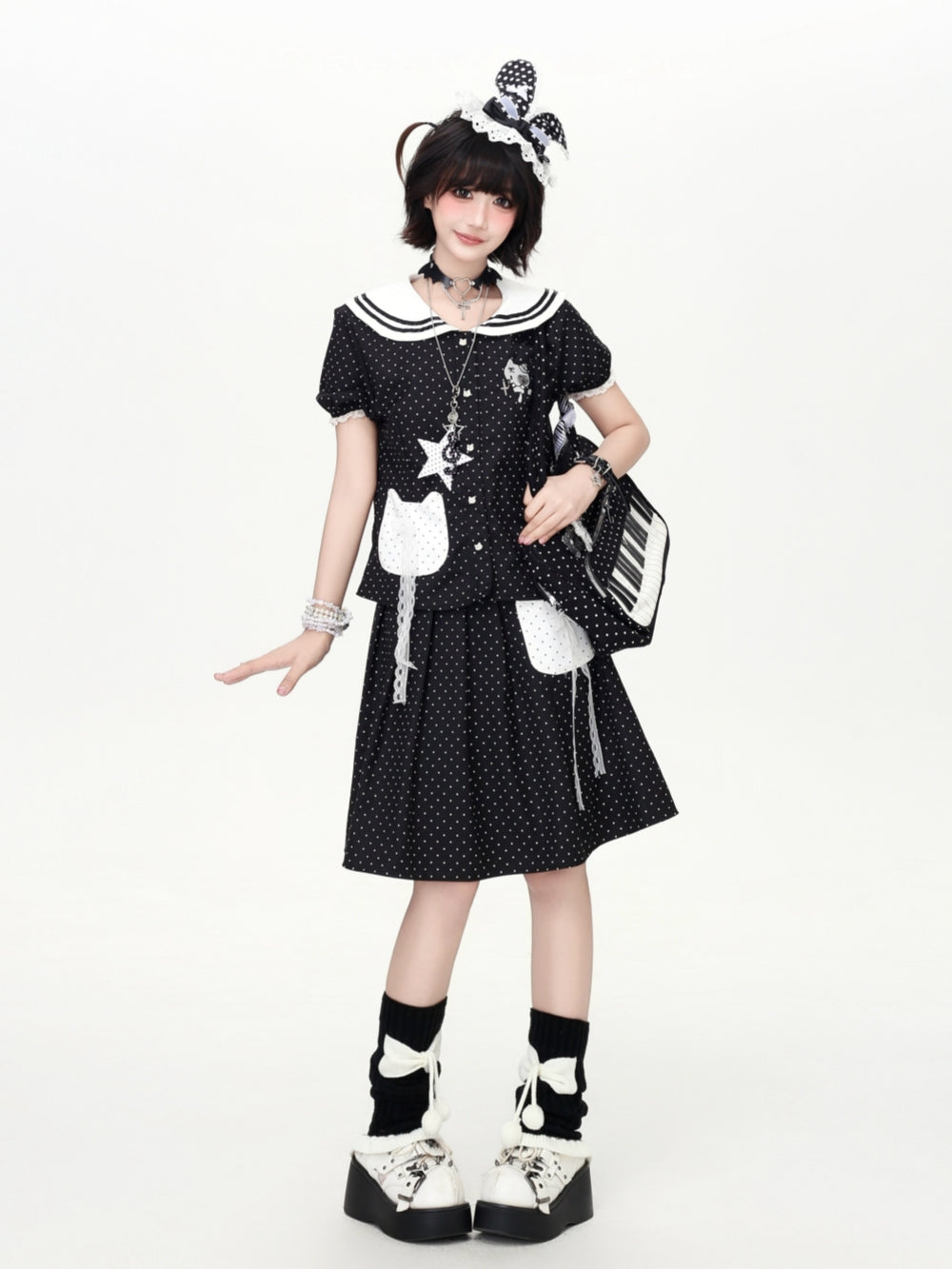 Model wearing a black polka dot Cyber Y2K kawaii sailor skirt set with a contrast white collar and cat patch pockets.