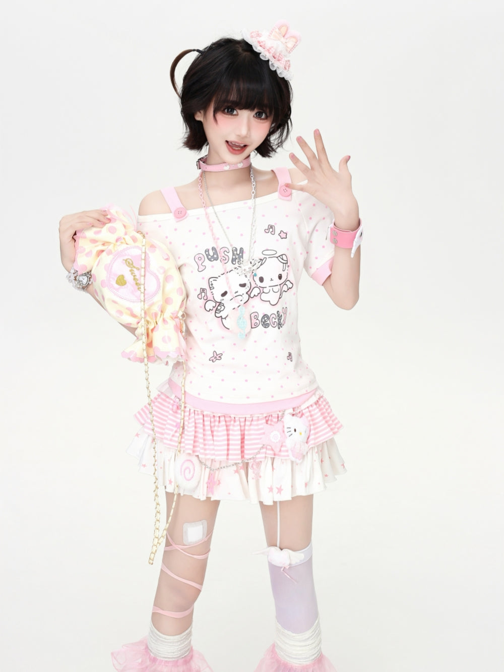 Model wearing a pastel pink and green Cyber Y2K kawaii anime graphic tee with contrast polka dots and cold-shoulder strap detail.