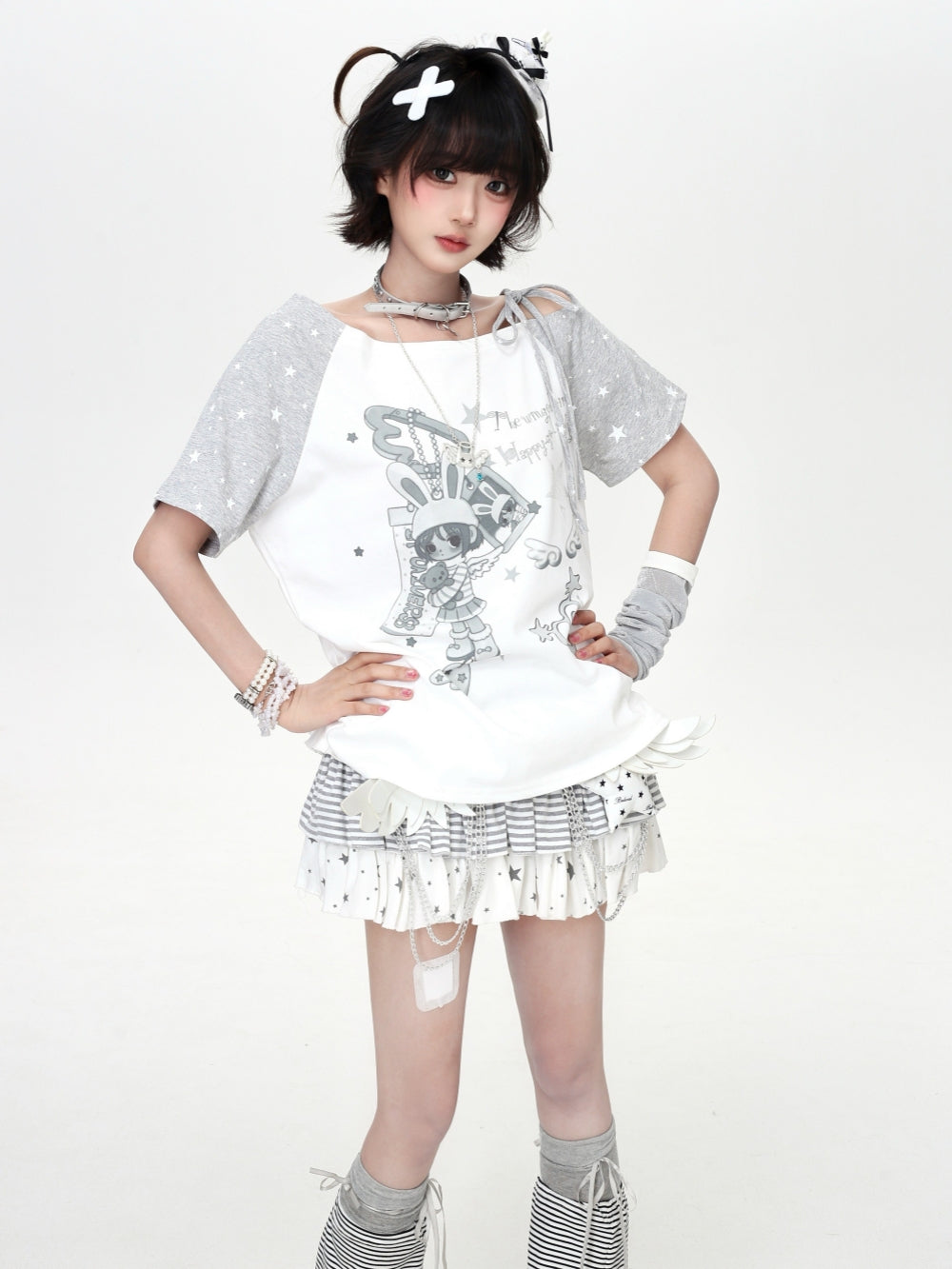 Model wearing a white and grey star-patterned Cyber Y2K cold shoulder graphic tee with a cute anime bunny character illustration.
