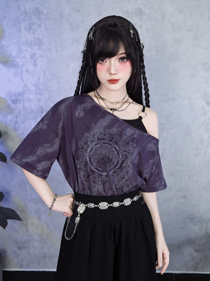 A model wearing a relaxed purple cyber grunge graphic tee with an asymmetric off-shoulder cut and an integrated O-ring shoulder strap, featuring a dark acid-wash graphic print.