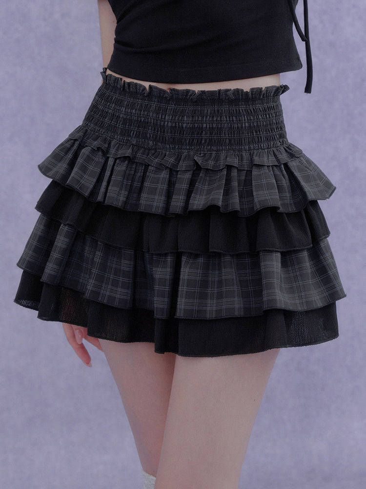 Model wearing a black and grey Cyber Y2K plaid tiered mini skirt with ruffle layers and smocked waist.