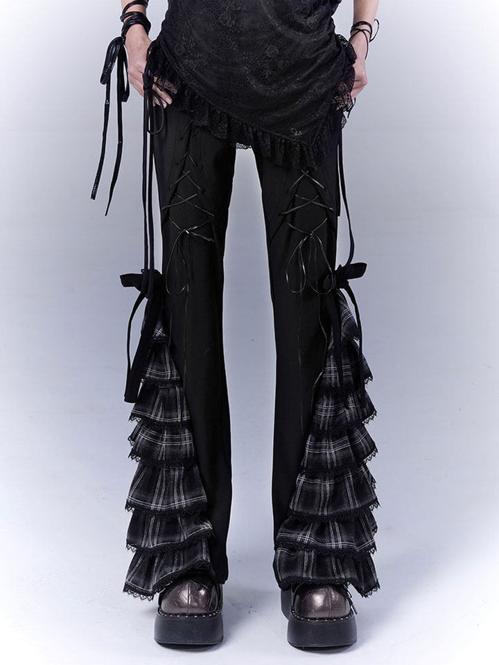 Black pants with crisscross lacing on the upper legs and tiered gray-and-black plaid ruffles widening the lower legs, topped by black bows.