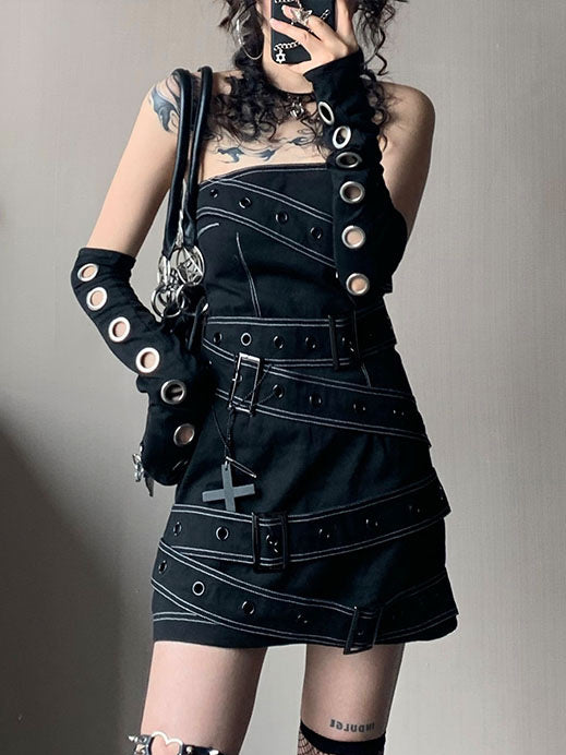 Black strapless punk mini dress with diagonal grommet straps and rectangular buckles, outlined by contrasting light stitching.