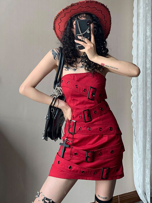 Red strapless punk mini dress with diagonal straps running across the bodice and skirt, accented by black grommets and rectangular buckles.