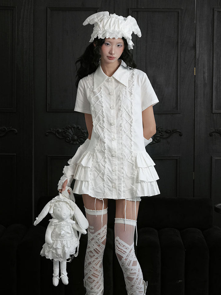 White collared long top with short sleeves, two ruffle-edged lace-up sections down the front and tiered ruffles at both sides.
